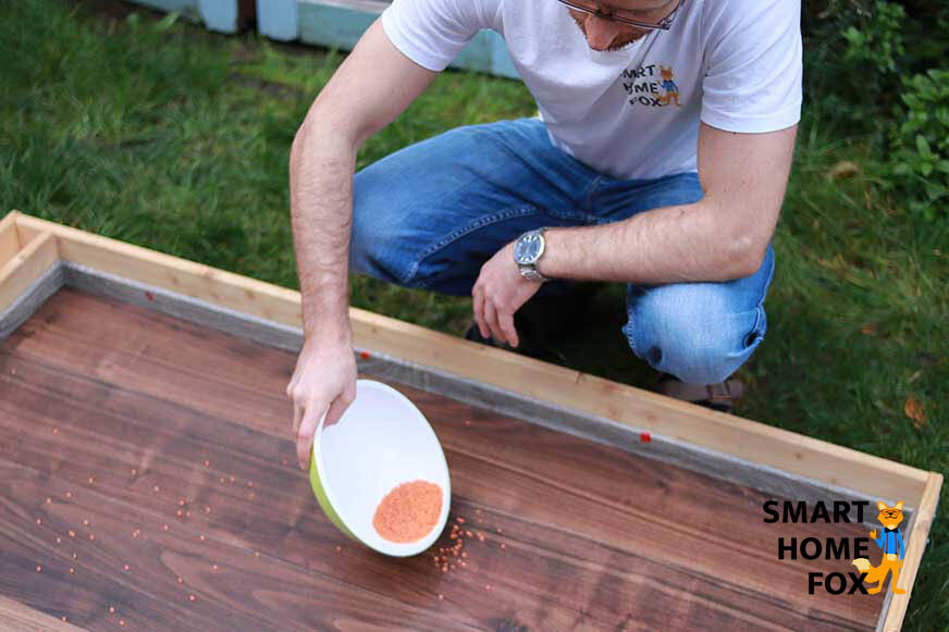 Schmutz wird auf einem Laminatboden für den Test der Saugleistung des Roomba j7 verteilt.